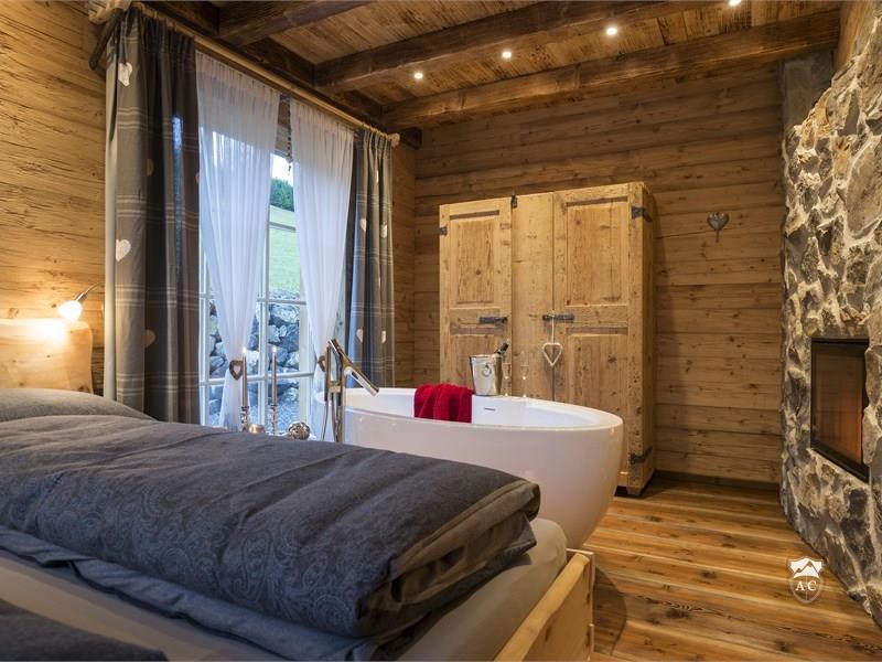 Master Bedroom mit freistehener Badewane und Kamin Chalet 1
