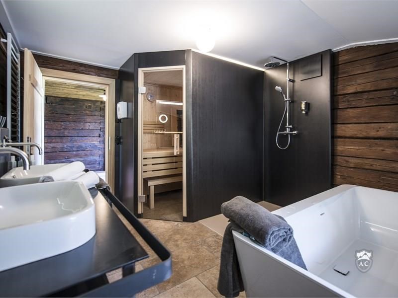 Badezimmer mit Sauna und freistehender Badewanne