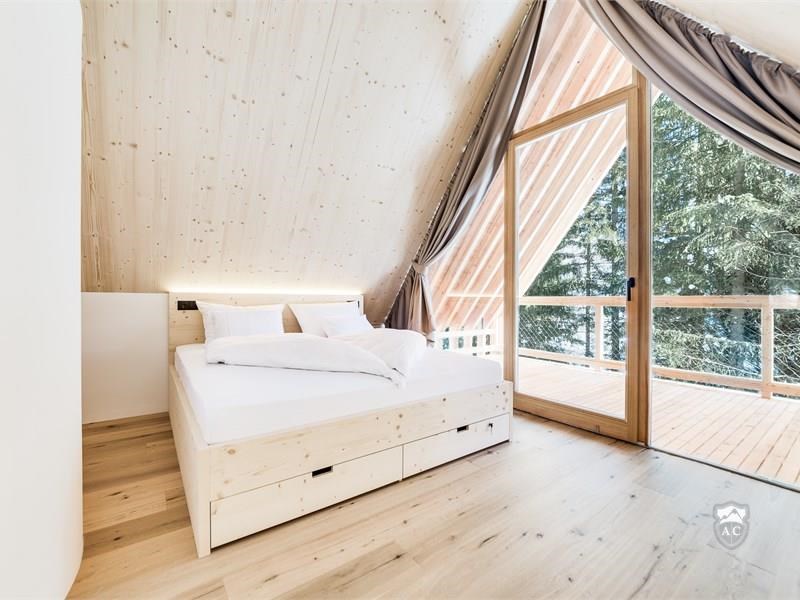 Schlafzimmer mit Sichtdachstuhl und Glasfront